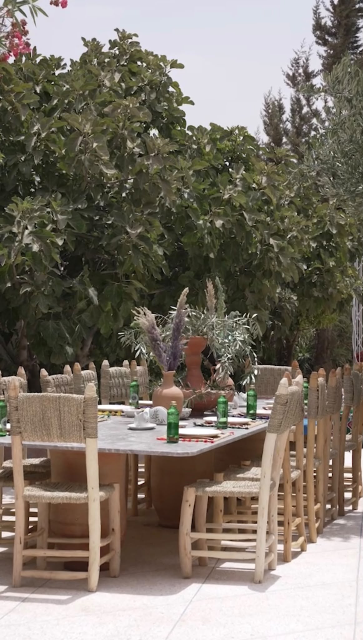 Handwoven chairs around the garden dining table at Dar Cherfa
